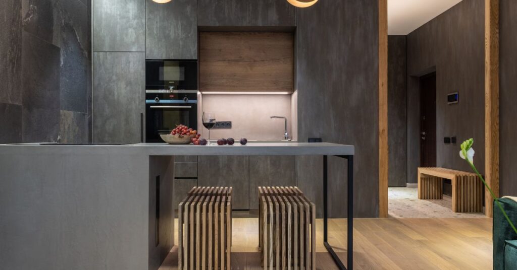 Kuchnia w stylu loftowym na wymiar – co warto wiedzieć, zanim wybierzesz projekt? 1 Stylowa ciemna kuchnia z wyspą i betonowym blatem